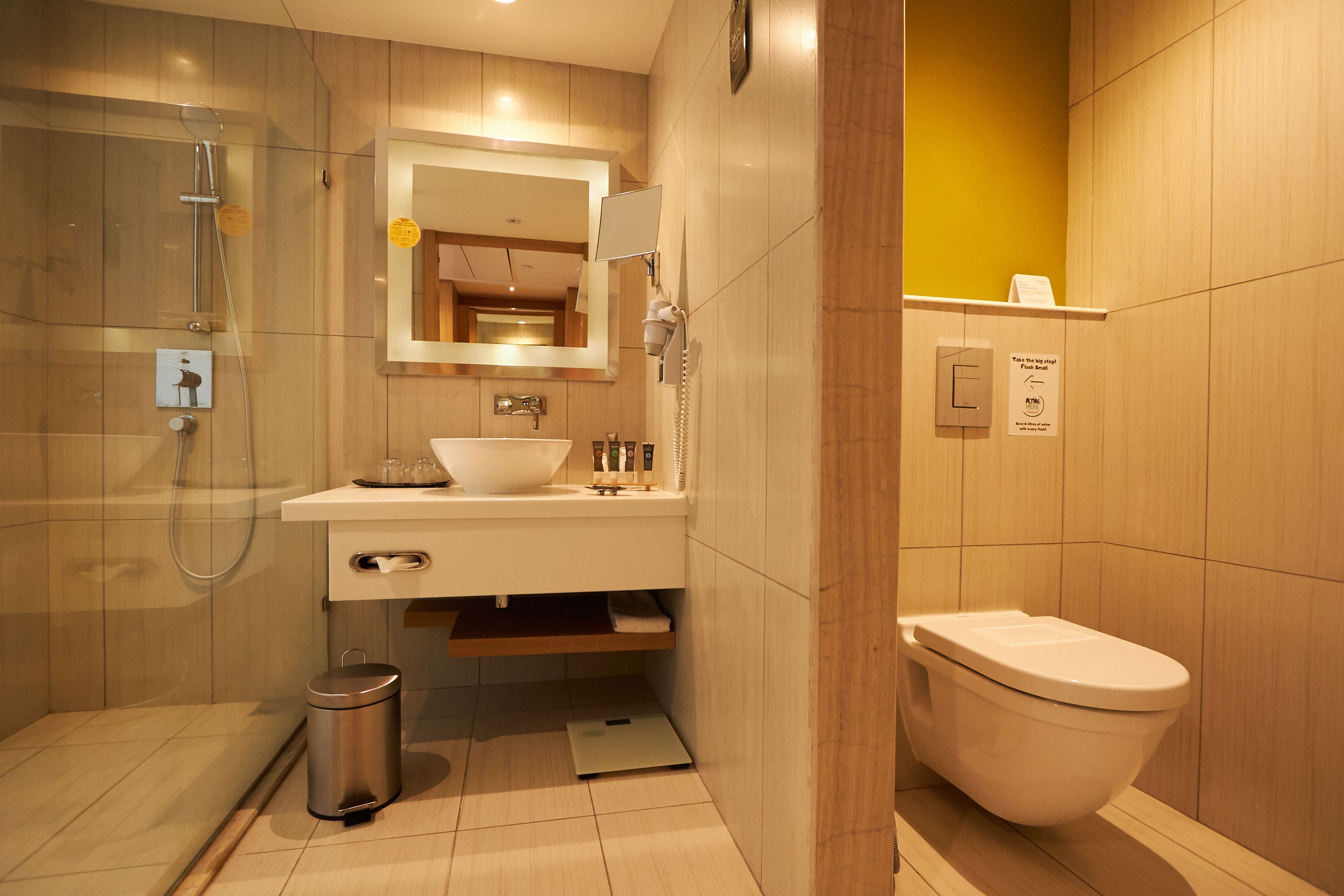 A modern bathroom with a shower, sink, and toilet.