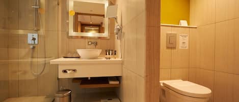 A modern bathroom with a shower, sink, and toilet.