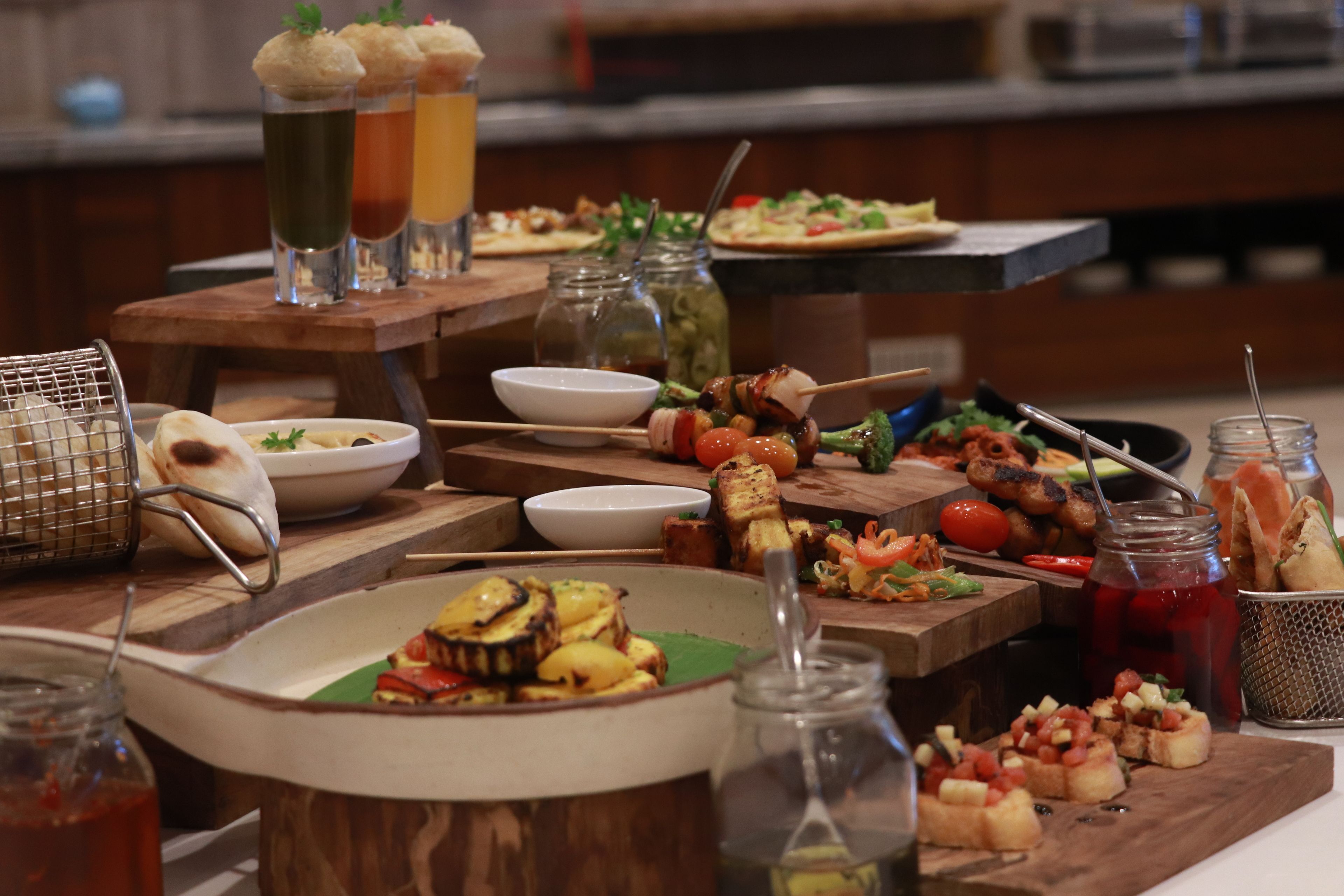 A buffet table with various dishes, drinks, and condiments.