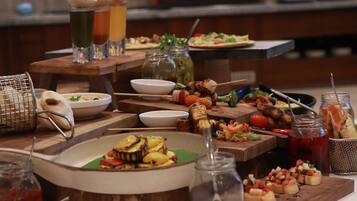 A buffet table with various dishes, drinks, and condiments.