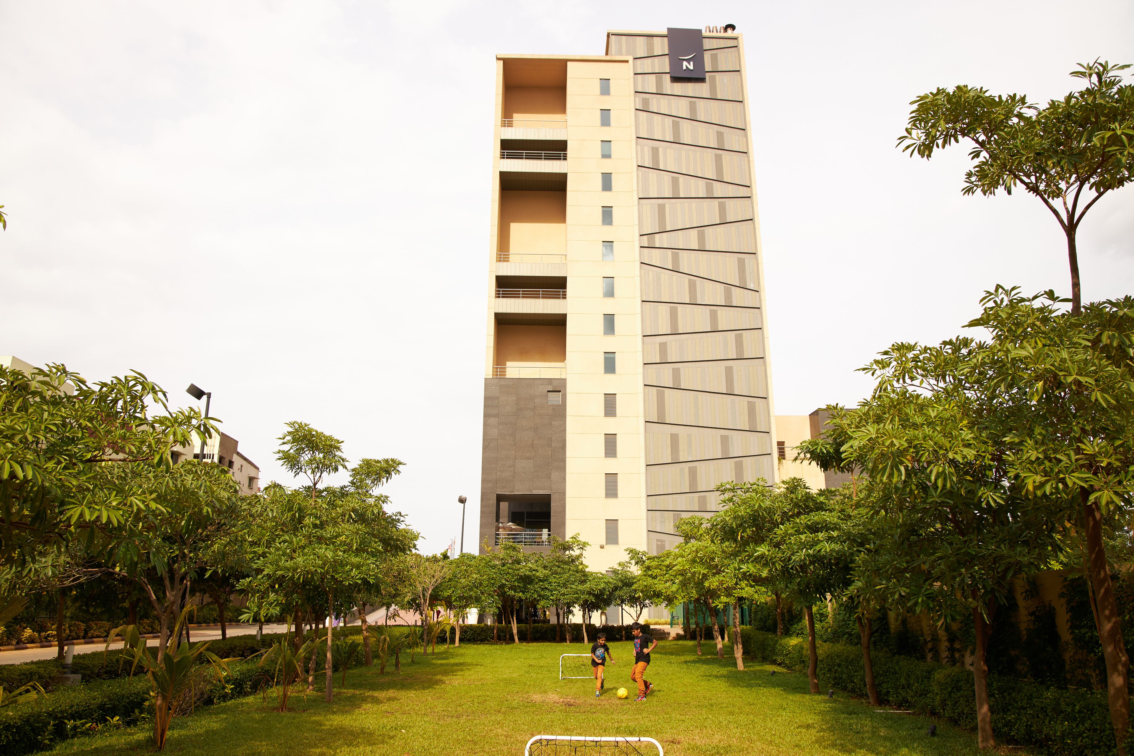 A modern building with a flat roof and a sign with the letter 'N'.