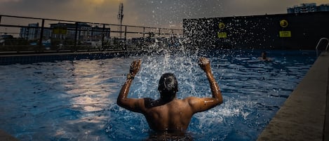 Una piscina al aire libre, sillones reclinables de piscina