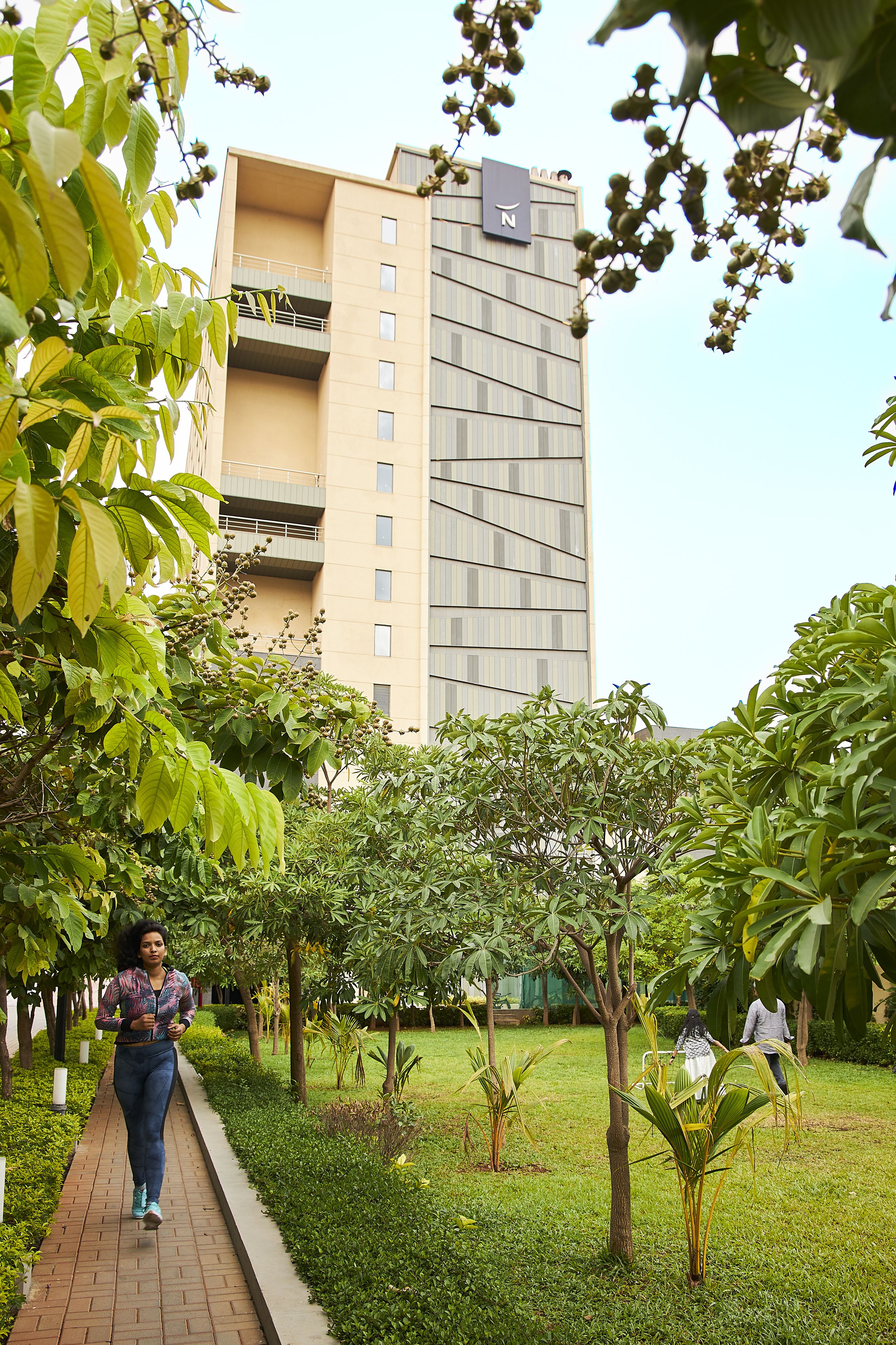 A pathway in a landscaped area with a building in the background.