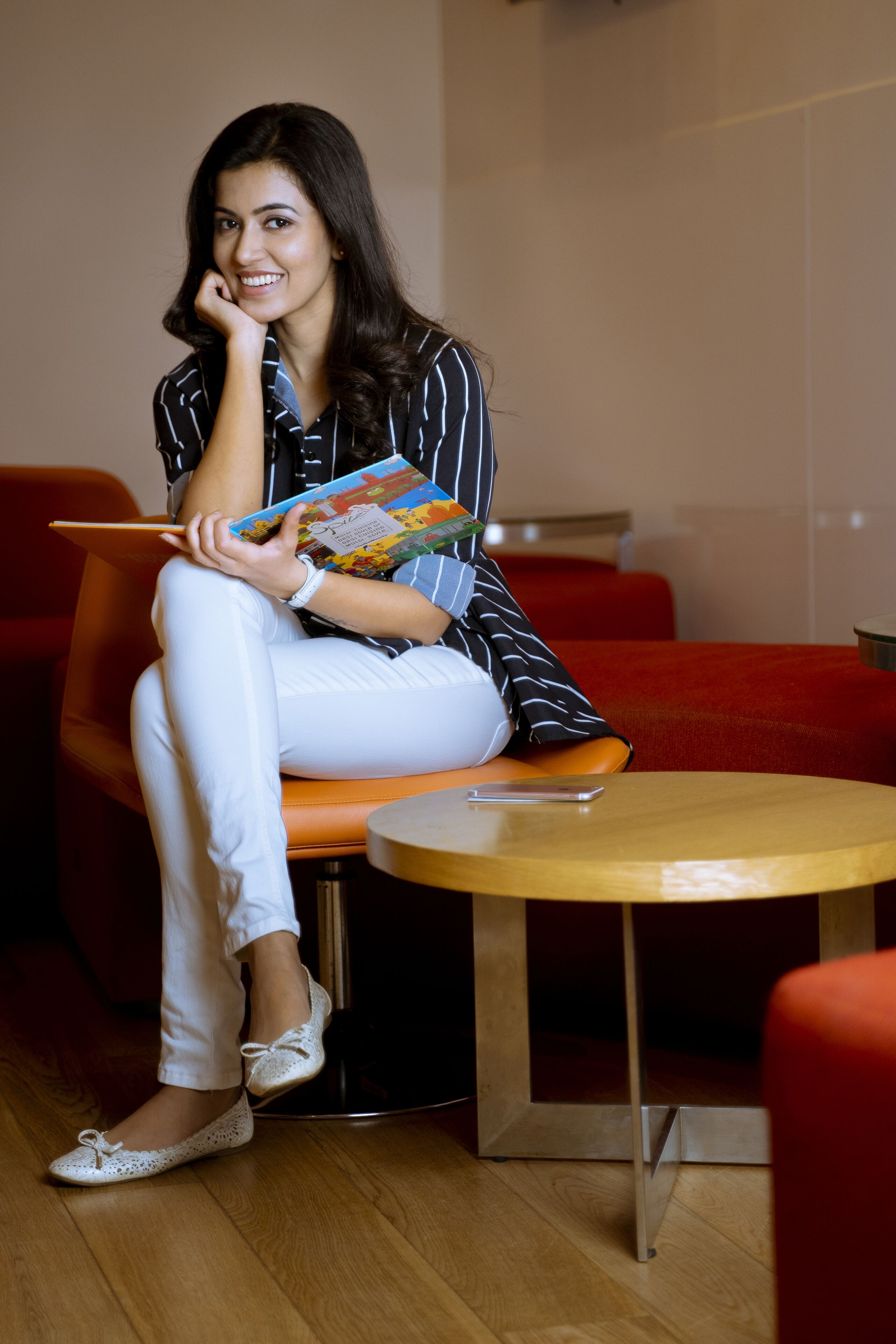 A person sitting on a red couch with a wooden table in front of them.