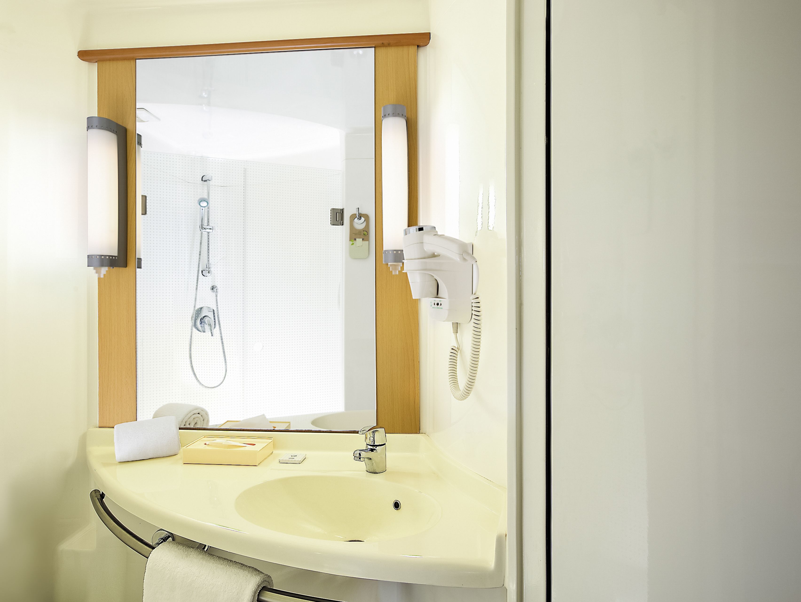 A bathroom with a sink, mirror, towel rack, and a hairdryer.