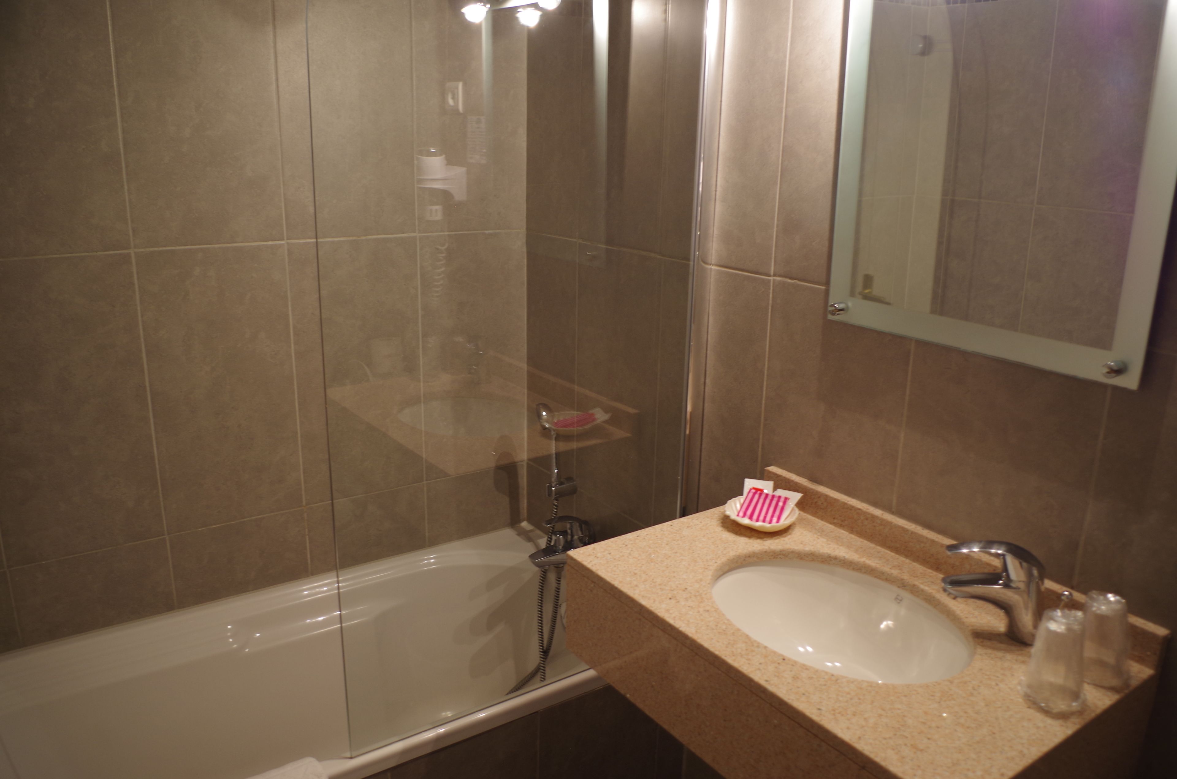 Une salle de bain avec une baignoire, un lavabo et un miroir.