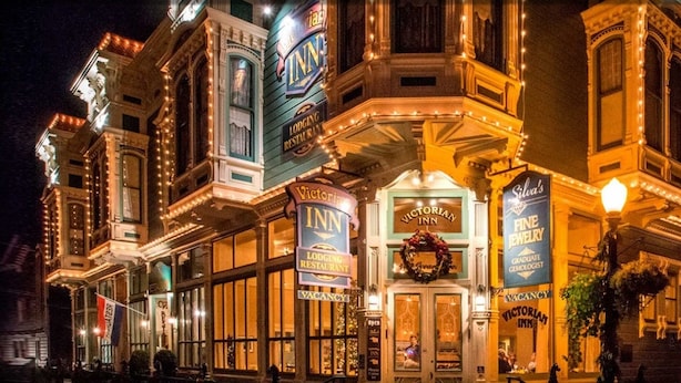 A Victorian-style building with multiple signs indicating it is a lodging and restaurant, including "Victoria Inn" and "Fine Jewelry." - Victorian Inn (Ferndale)