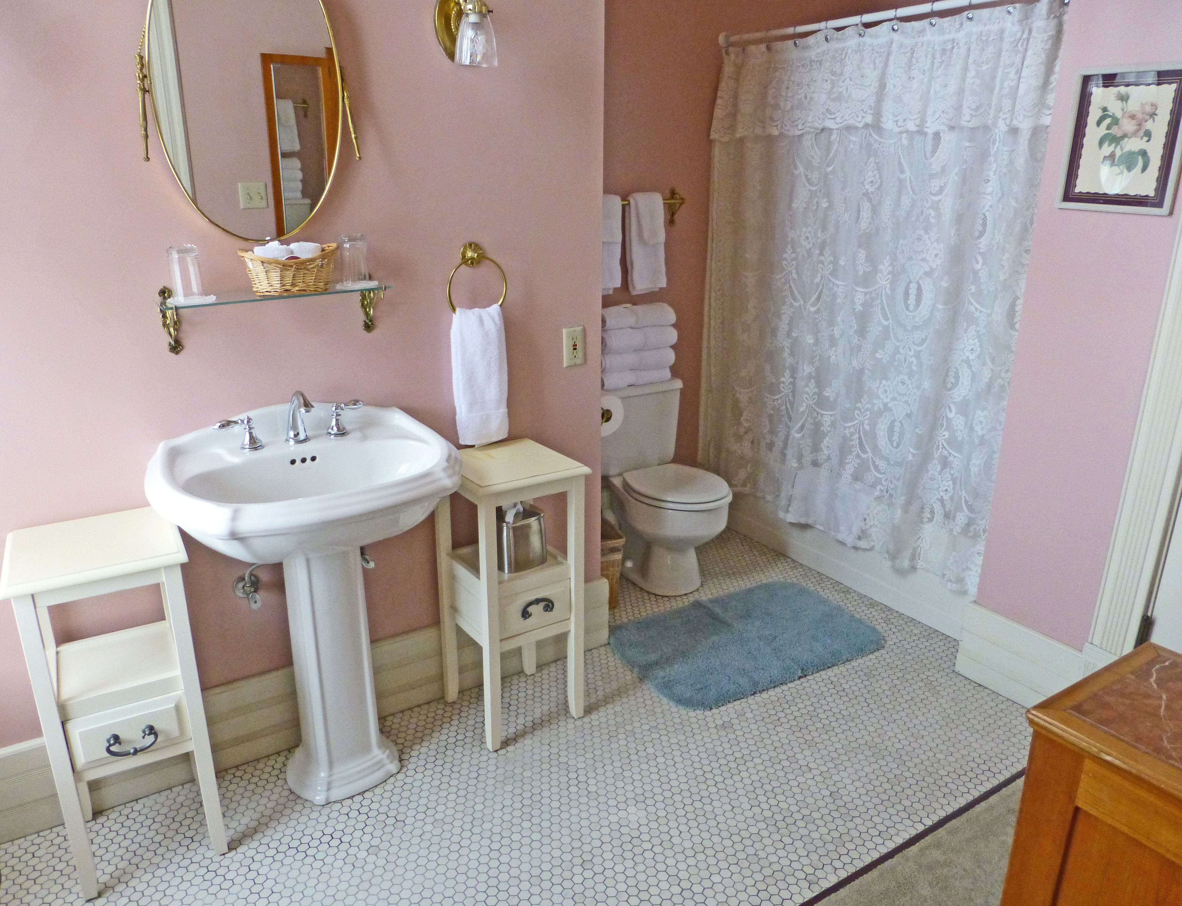 A bathroom with a white sink, toilet, and a shower curtain.