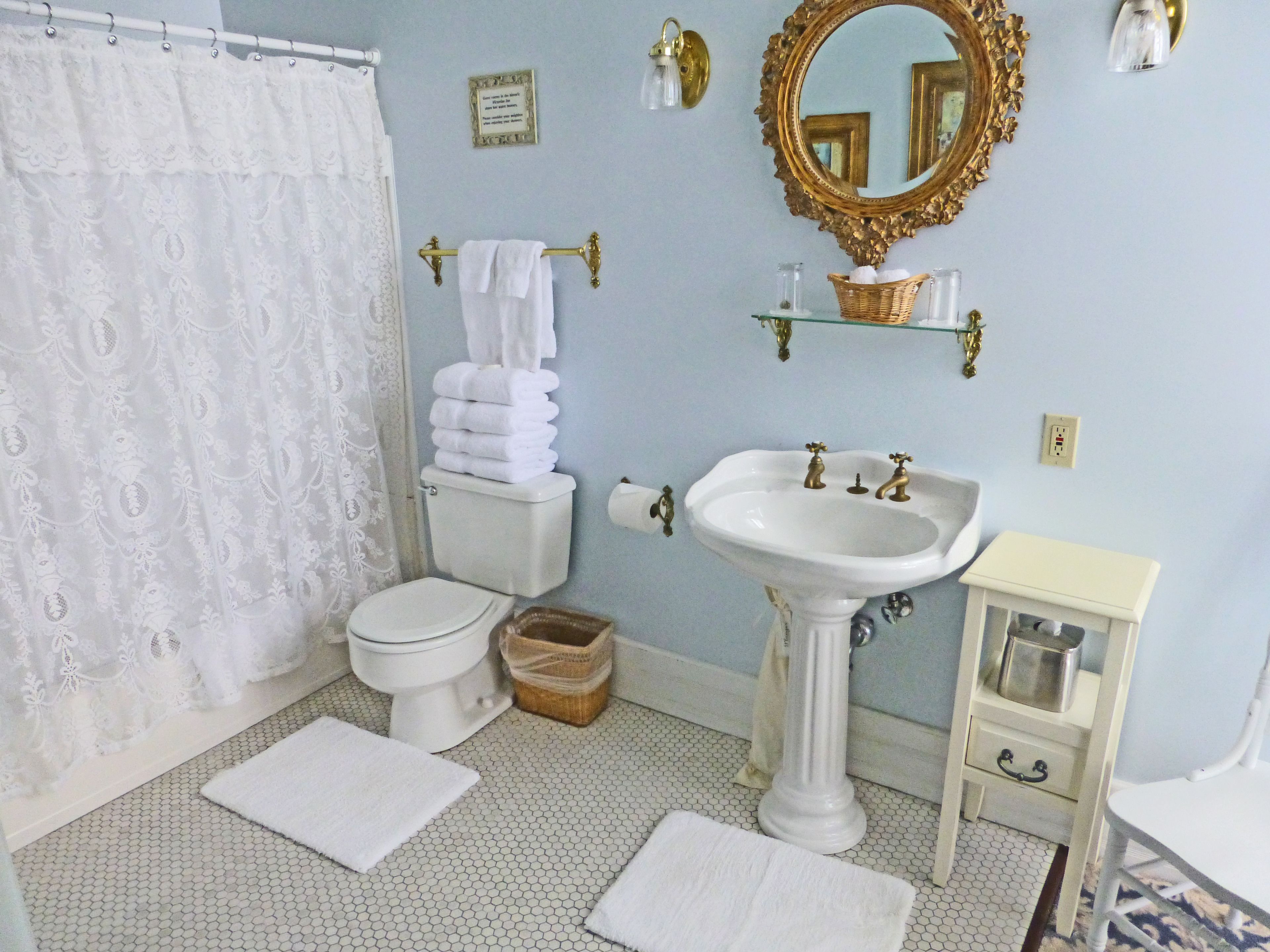 A bathroom with a toilet, sink, and a mirror.