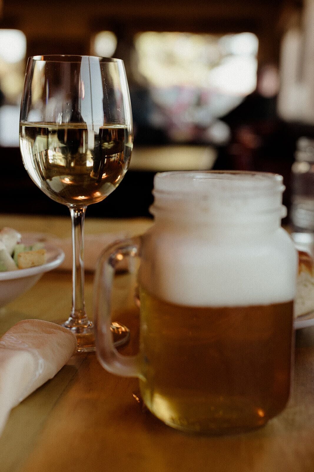 A glass of beer and a mug on a table.