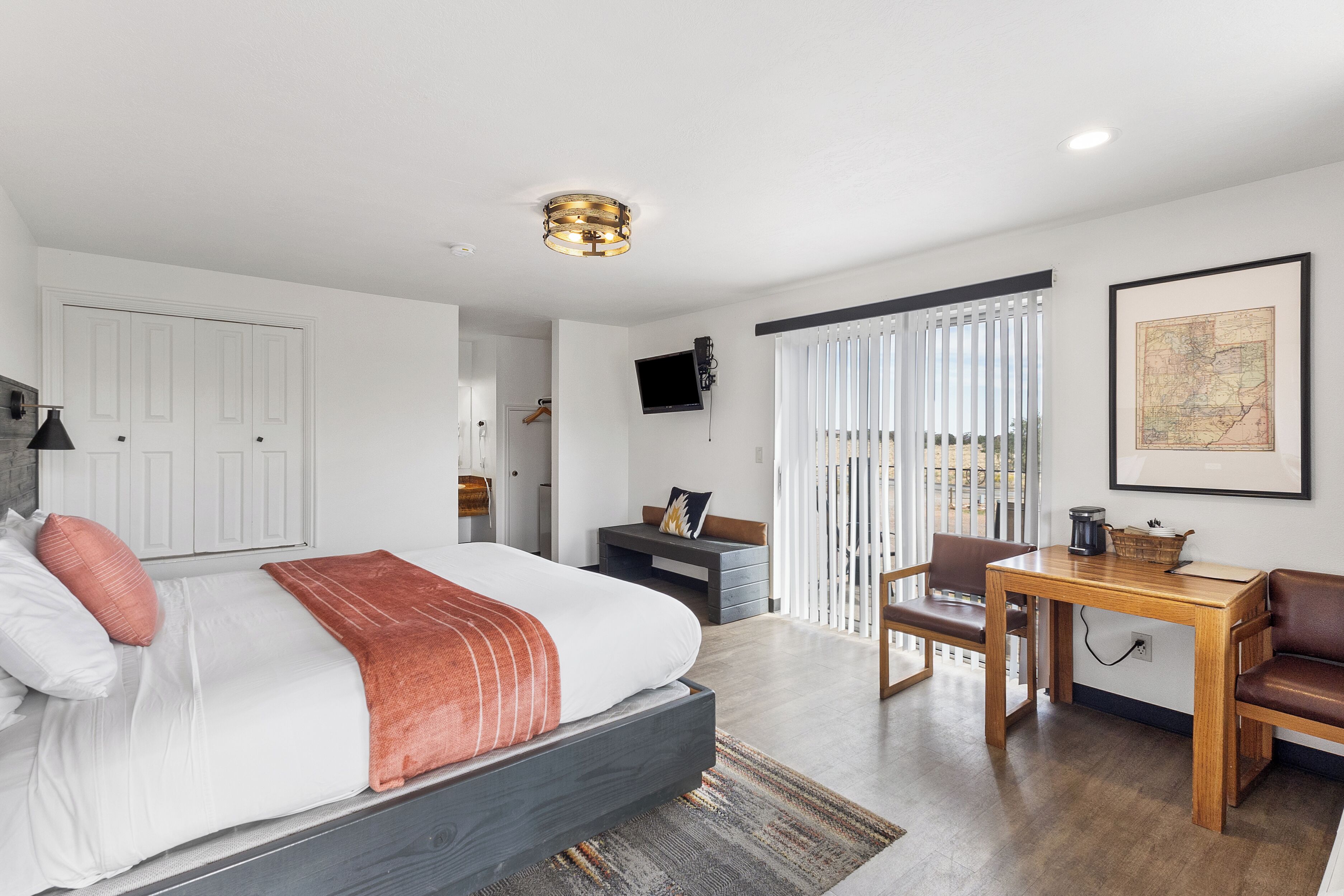 Un dormitorio moderno con una cama grande, un escritorio y un televisor.