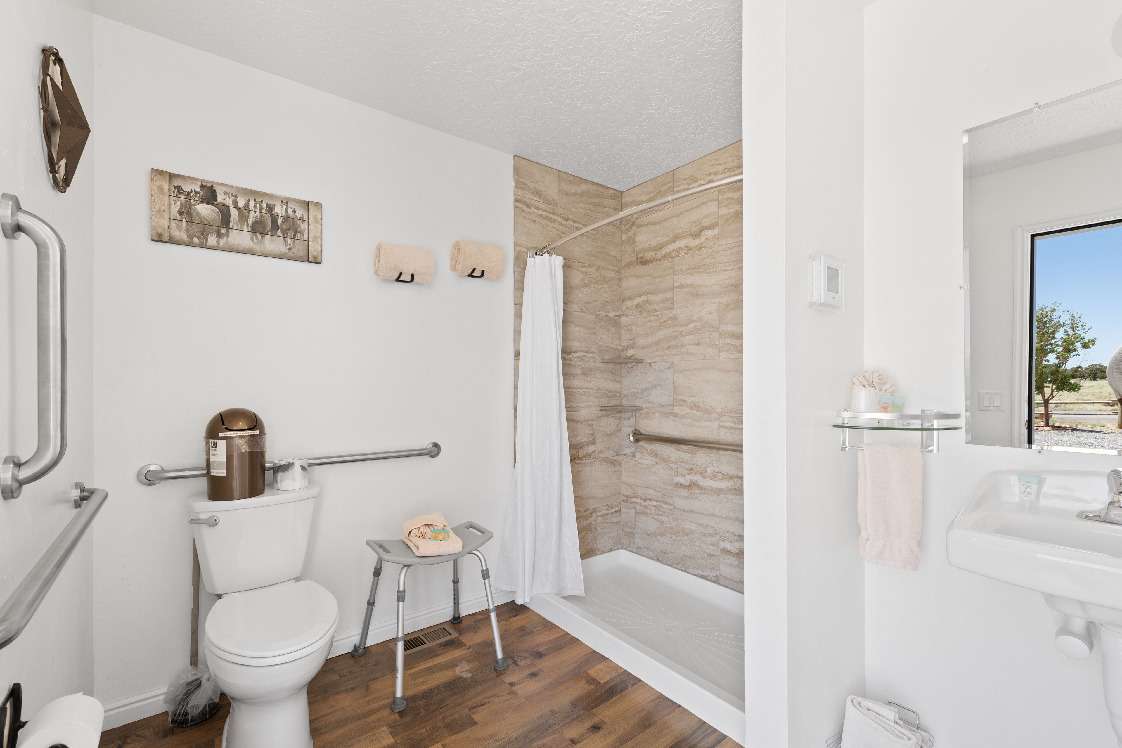 A bathroom with a toilet, shower, and sink.