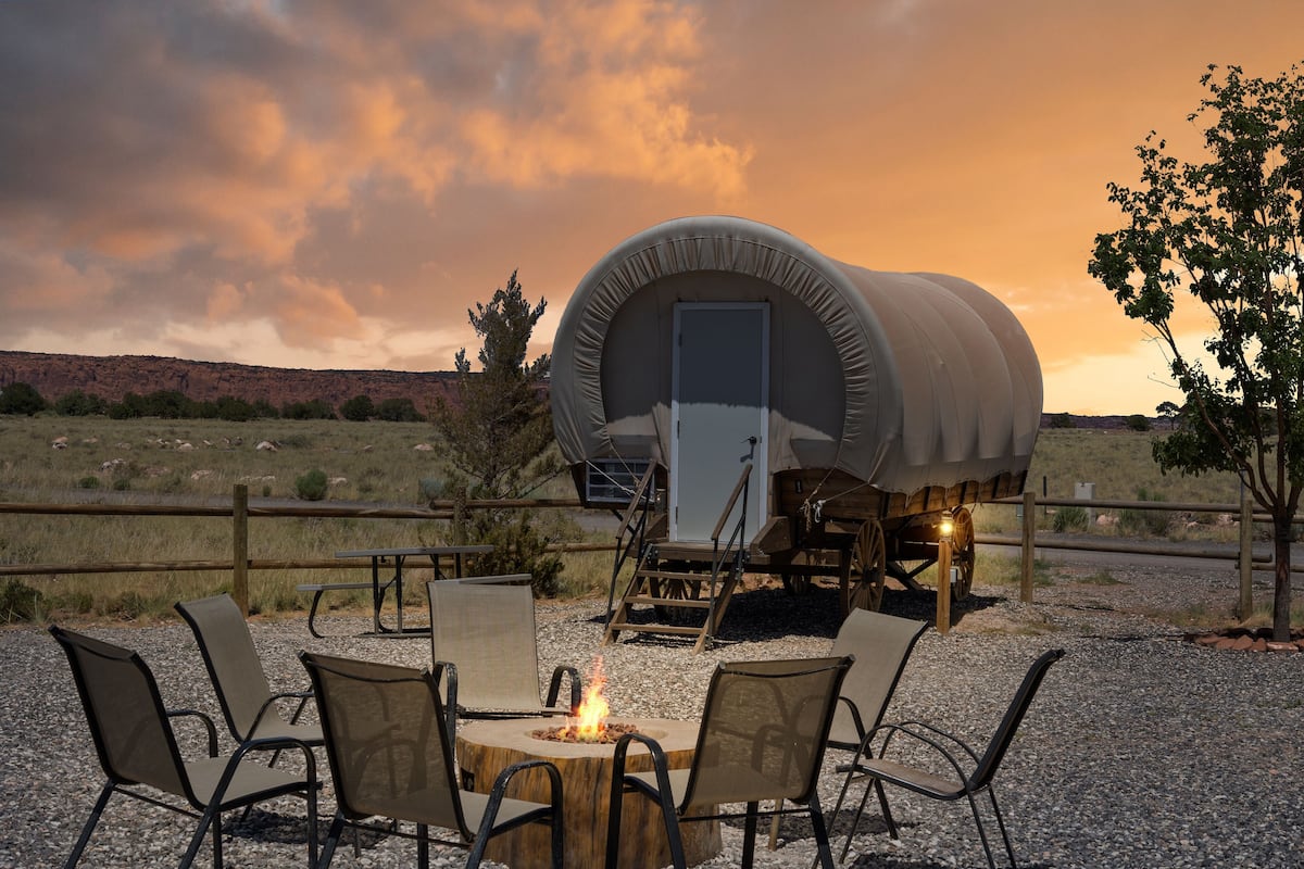 A covered RV with a fire pit and outdoor seating area.