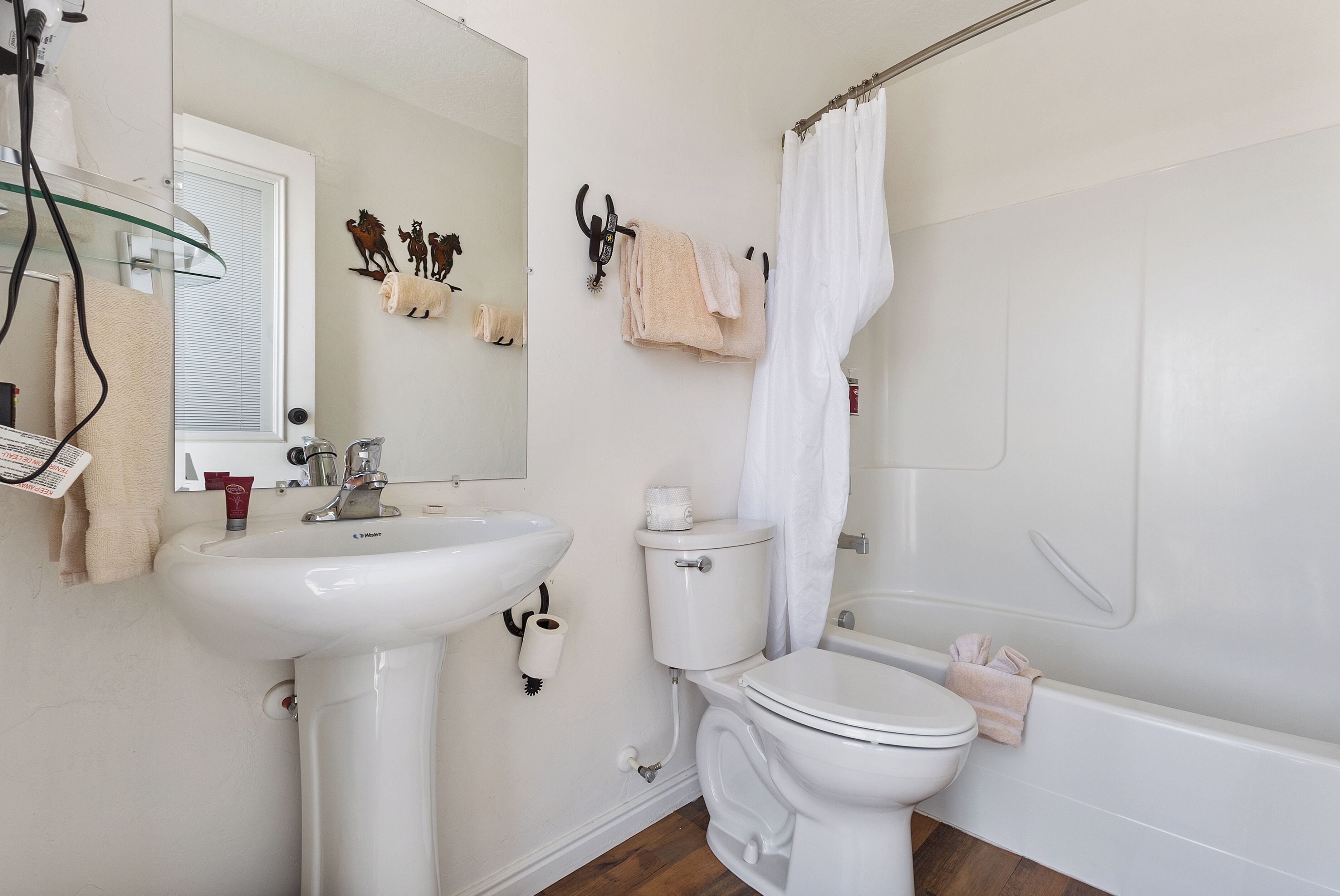 Un baño con lavamanos, inodoro y bañera blancos.