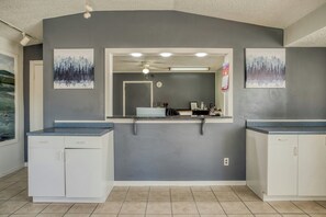 A bathroom with a grey wall, a mirror, a ceiling fan, and two sinks.
