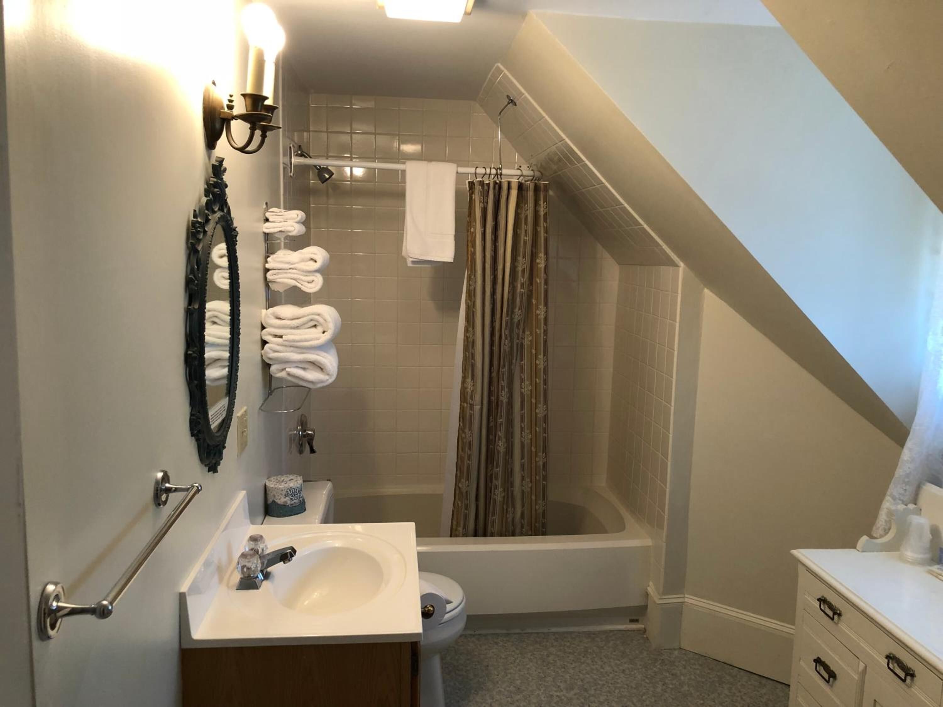A bathroom with a bathtub, toilet, sink, and towel rack.