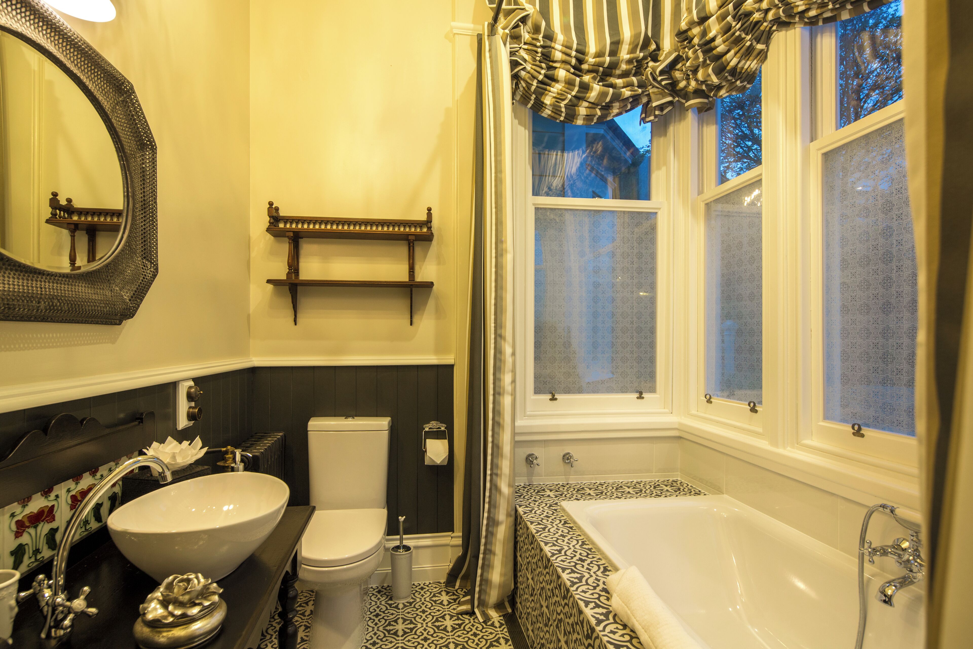 A bathroom with a large oval sink, a toilet, and a bathtub.