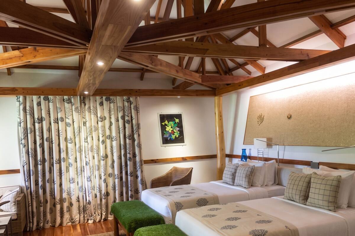 A room with two beds, a desk, and a chair.