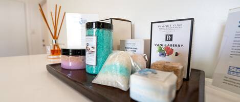 Un plateau contenant divers articles de toilette, notamment un flacon de lotion, un savon et une bougie parfumée.