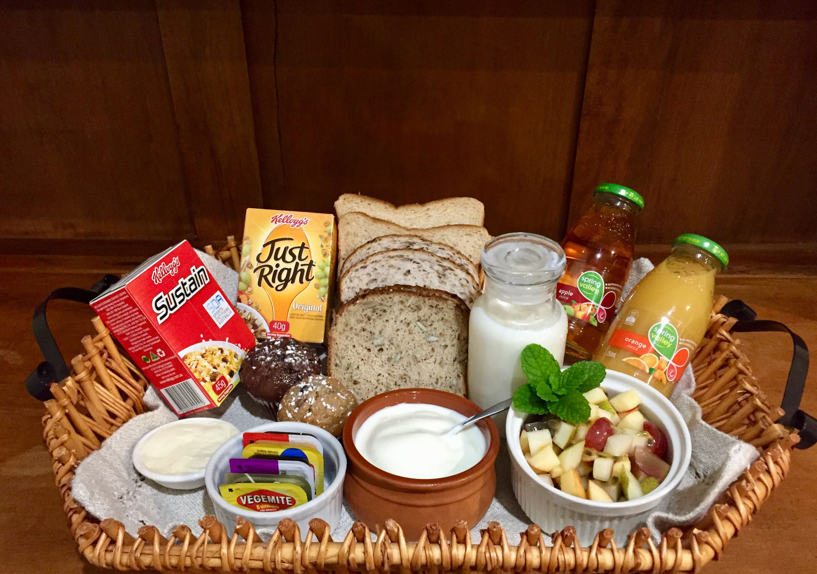 A variety of food items including bread, milk, yogurt, and fruit arranged on a tray.