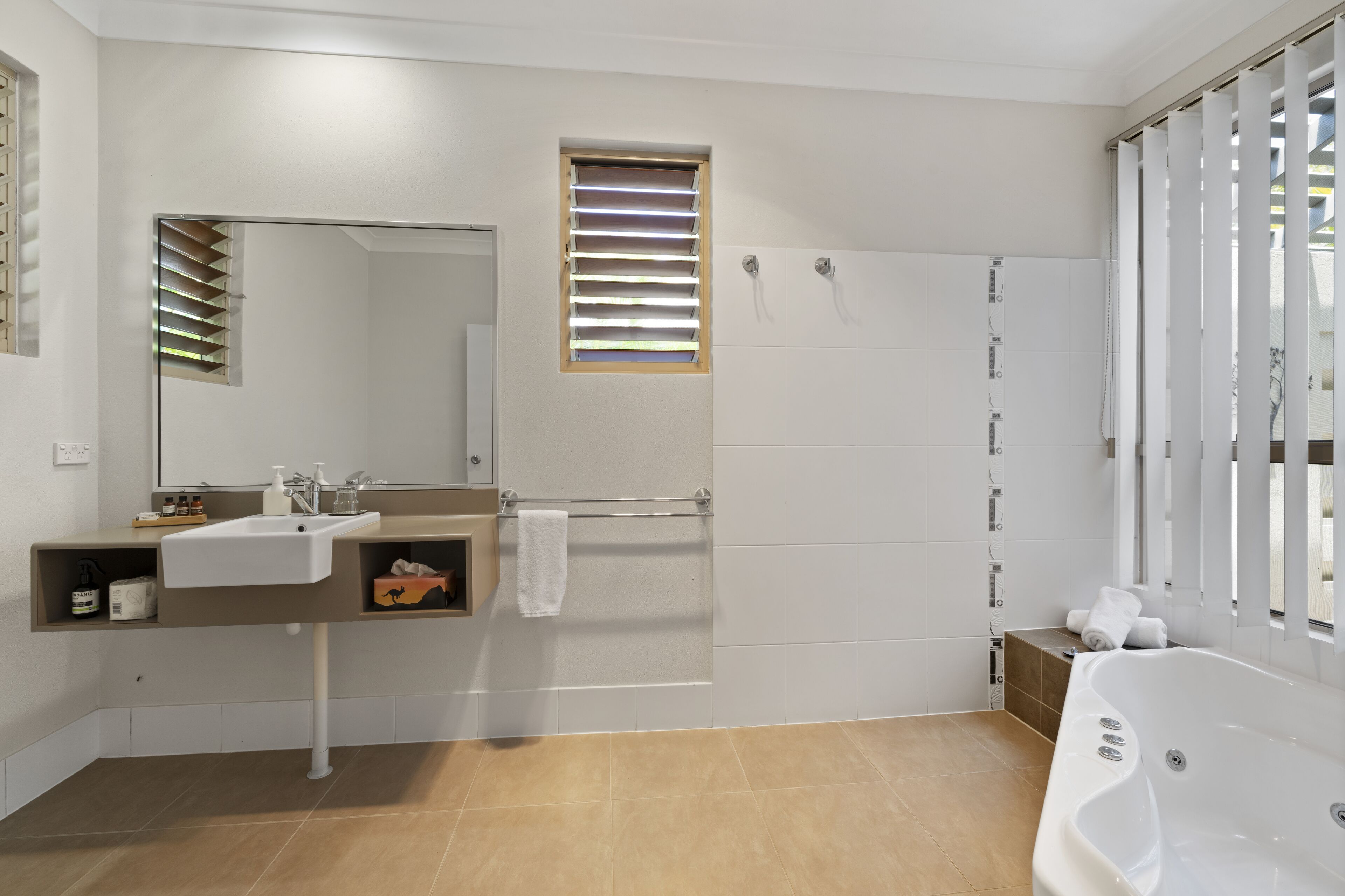 A modern bathroom with a sink, mirror, towel rack, shower, and bathtub.
