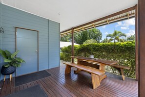 Eine Holzterrasse mit Picknicktisch und einem Blumentopf.