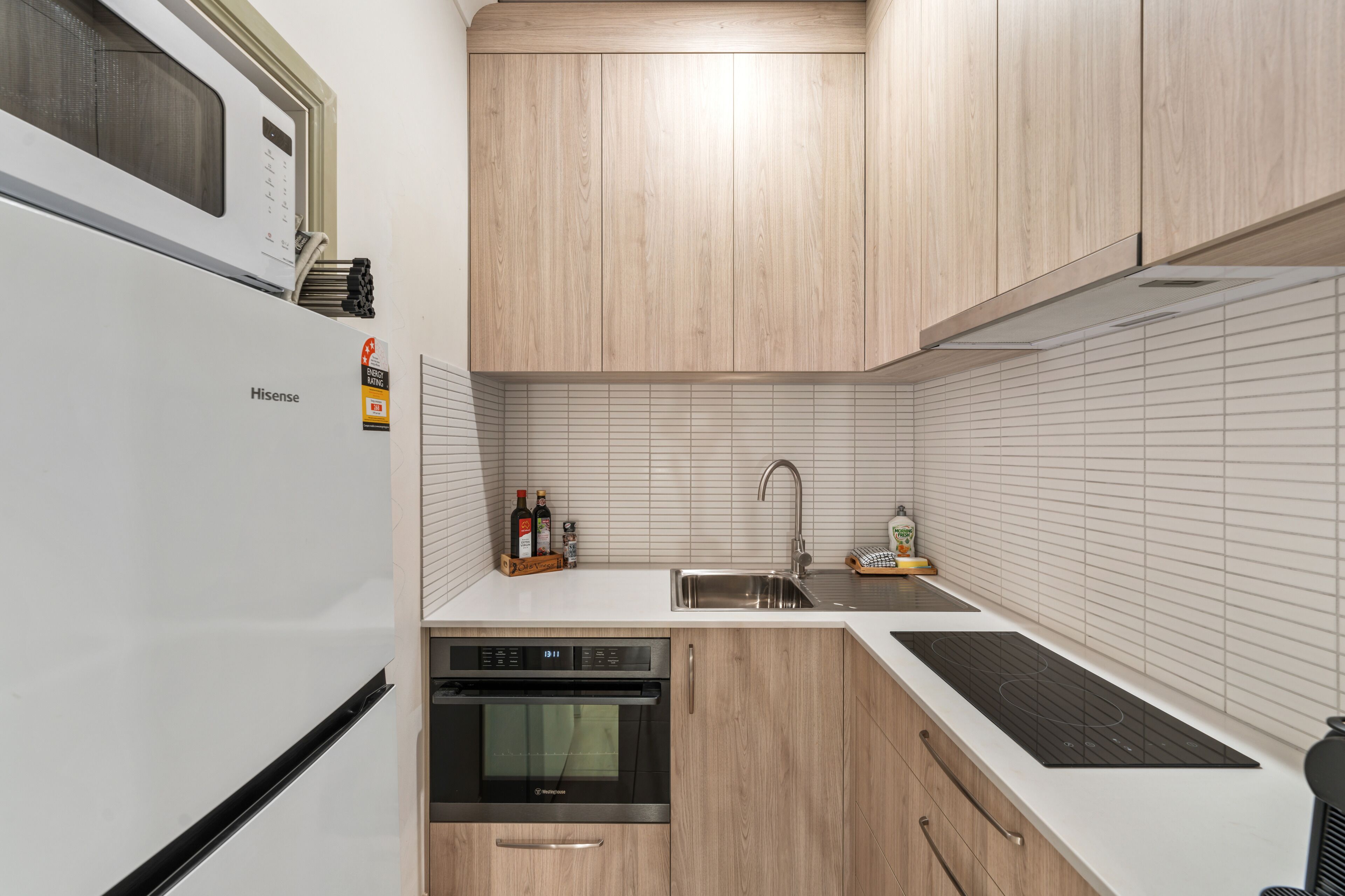 A compact kitchen with a built-in oven, a microwave, and a sink.