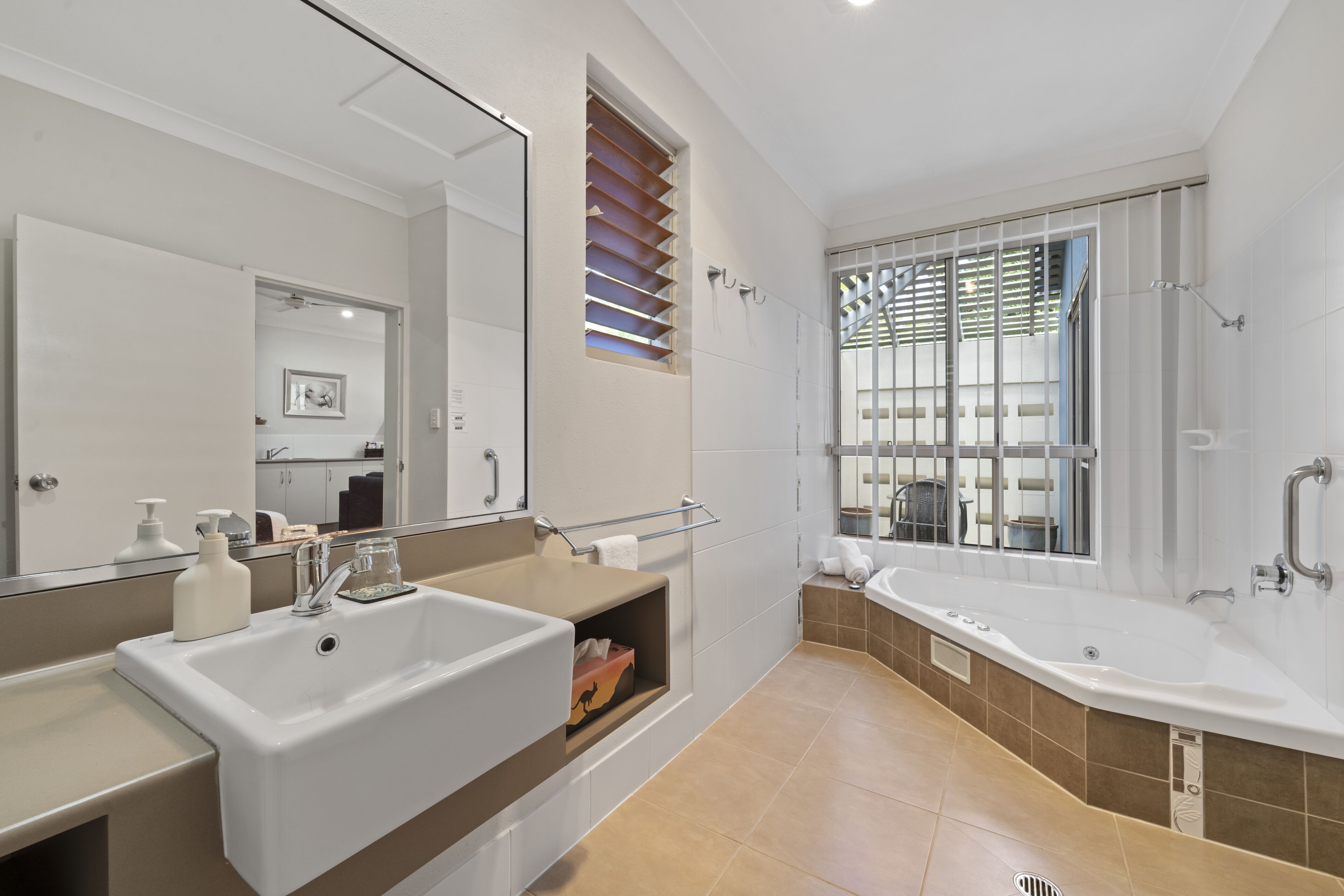 Un baño moderno con un lavamanos grande, una bañera y una zona de ducha.