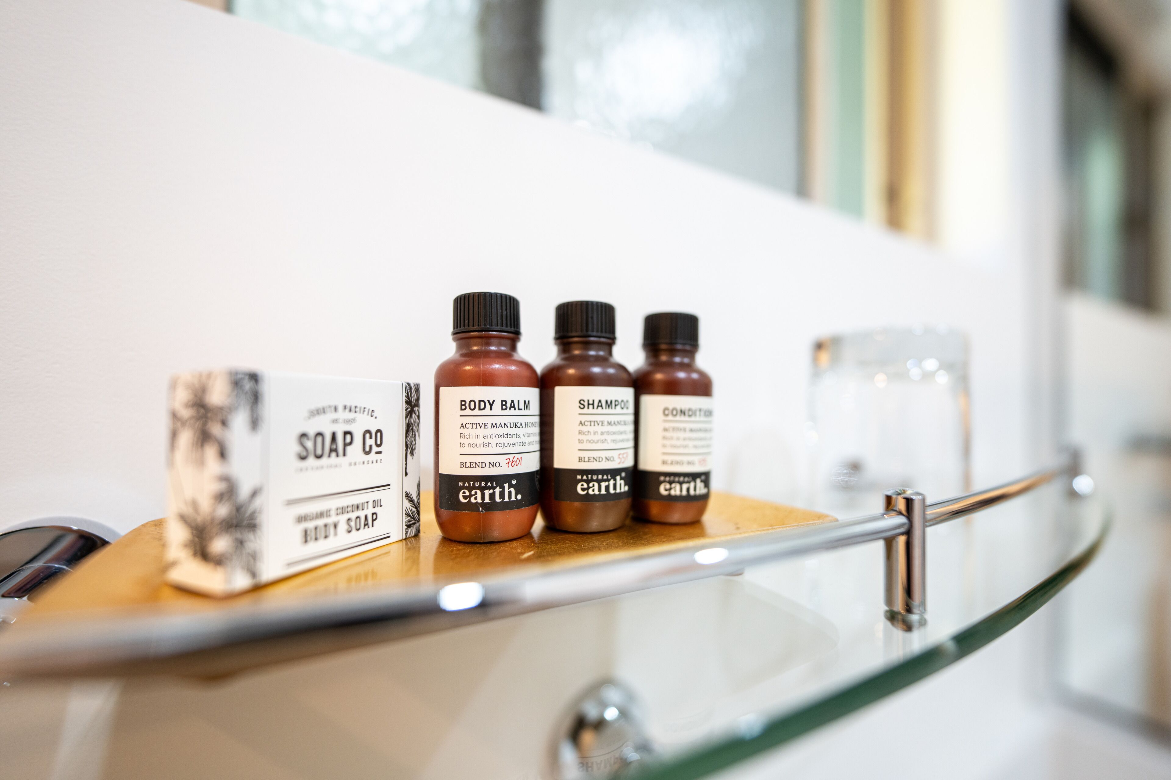 A shelf with bottles of body care products and a box of soap.