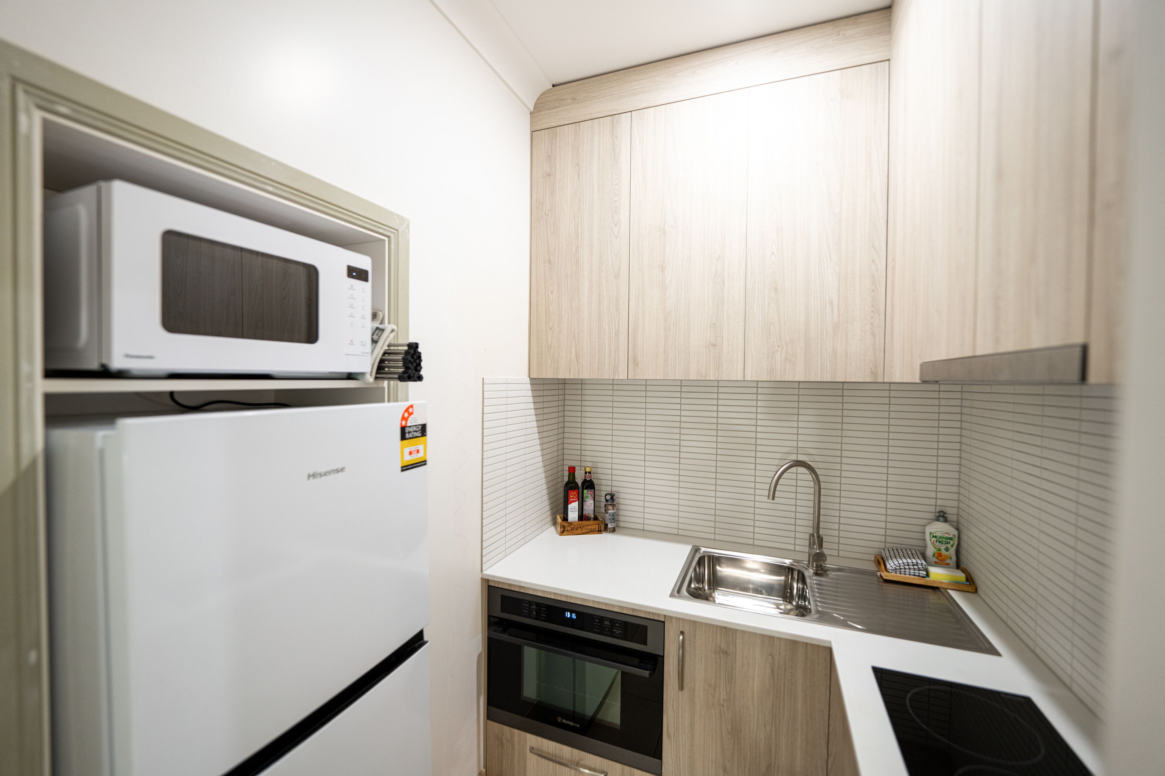A compact kitchen with a microwave, refrigerator, dishwasher, and sink.