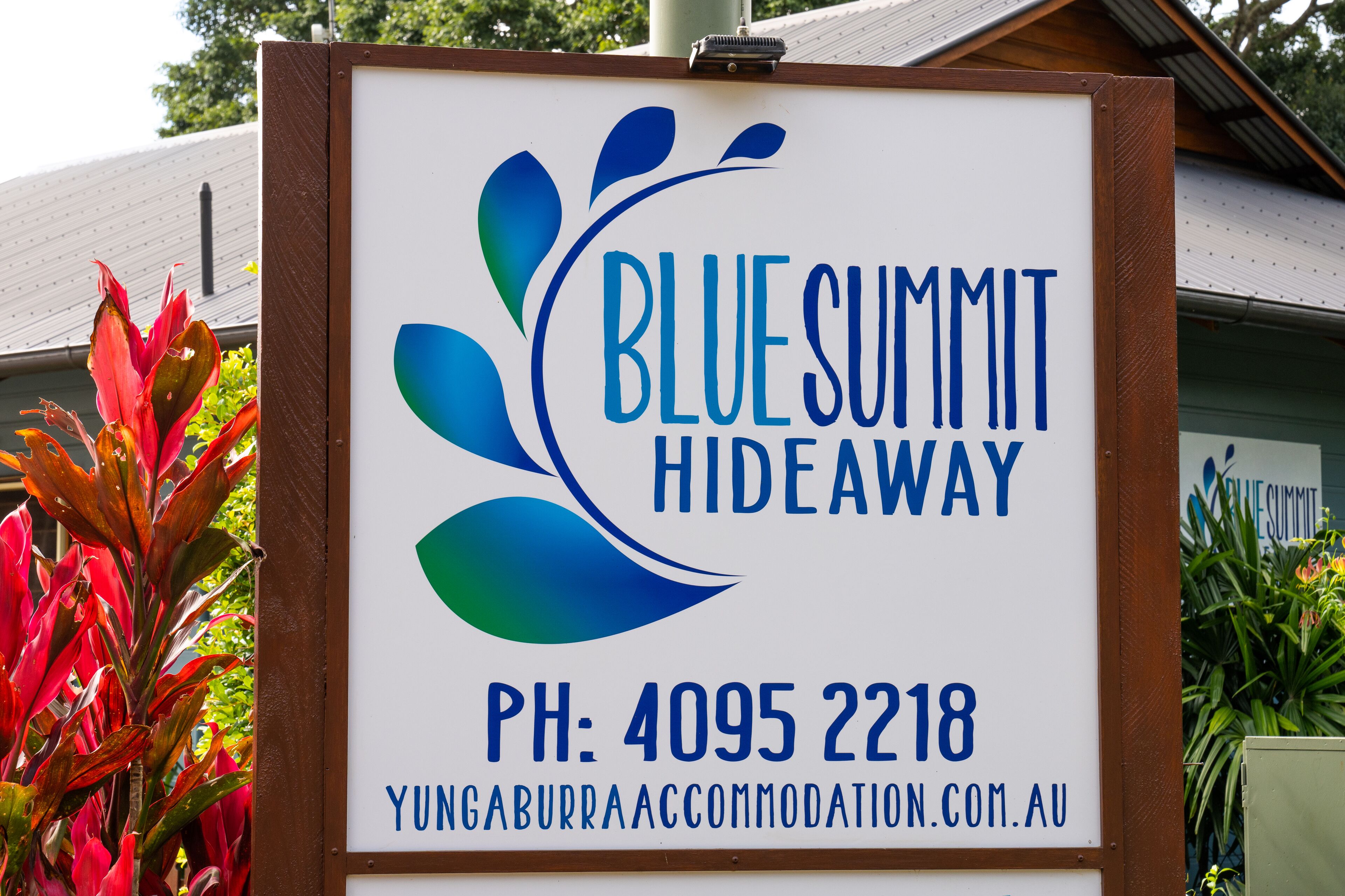 A sign for Blue Summit Hideaway with contact information and website URL.
