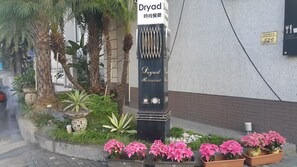 A Dryad Restaurant sign with a modern design, surrounded by lush greenery and potted plants. - Dryad Motel (Tainan)
