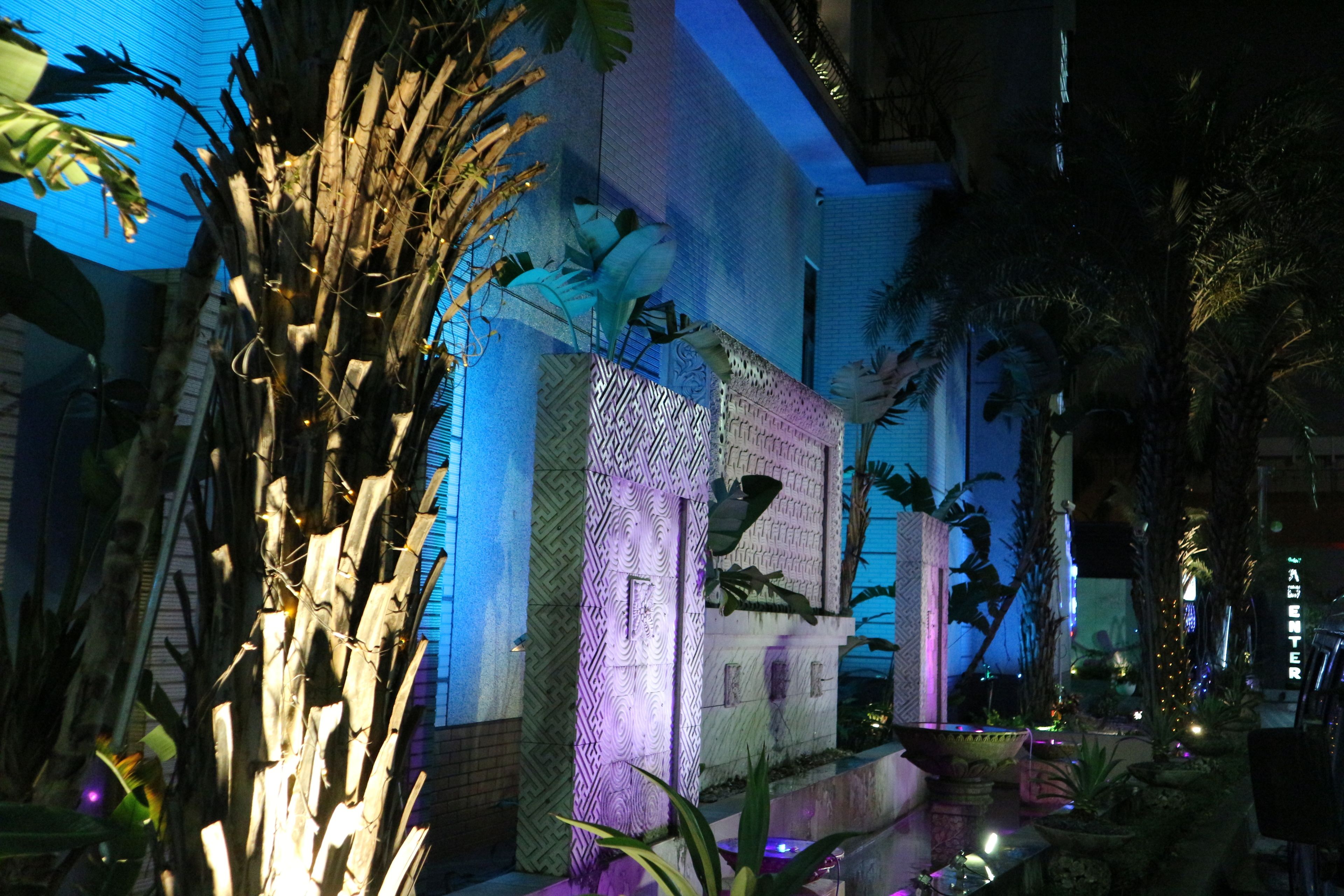 A modern building with patterned walls and a water feature in the foreground.