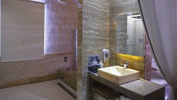 A modern bathroom with a marble sink, a large mirror, and a bathtub.