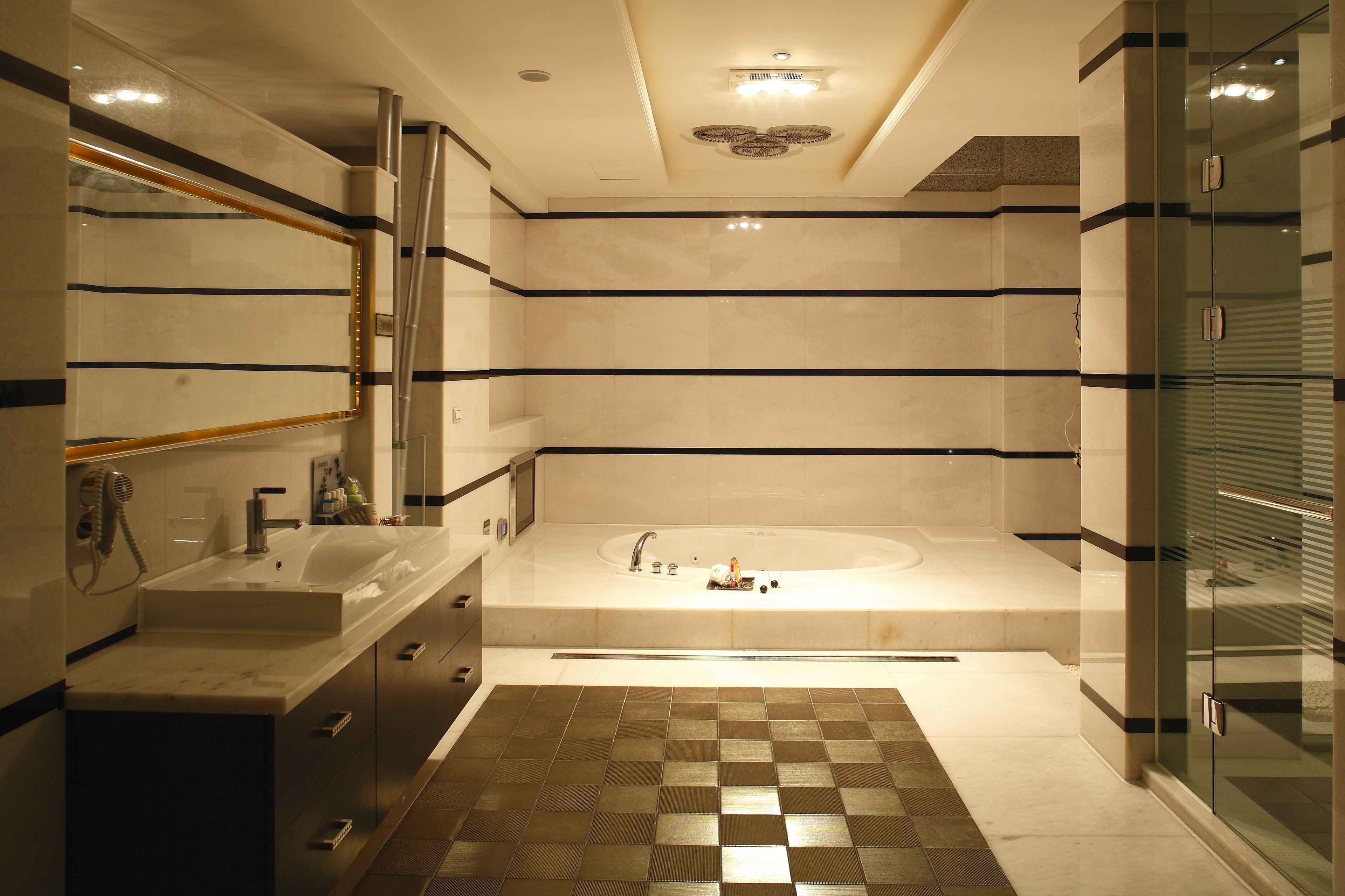 Un baño moderno con una bañera grande, un tocador con espejo y una zona de ducha.
