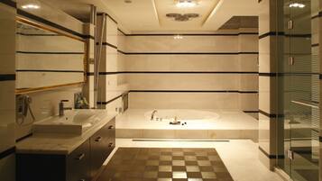 Un baño moderno con una bañera grande, un tocador con espejo y una zona de ducha.