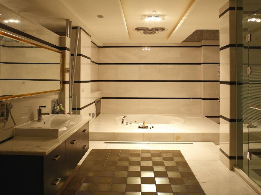 Un baño moderno con una bañera grande, un tocador con espejo y una zona de ducha.