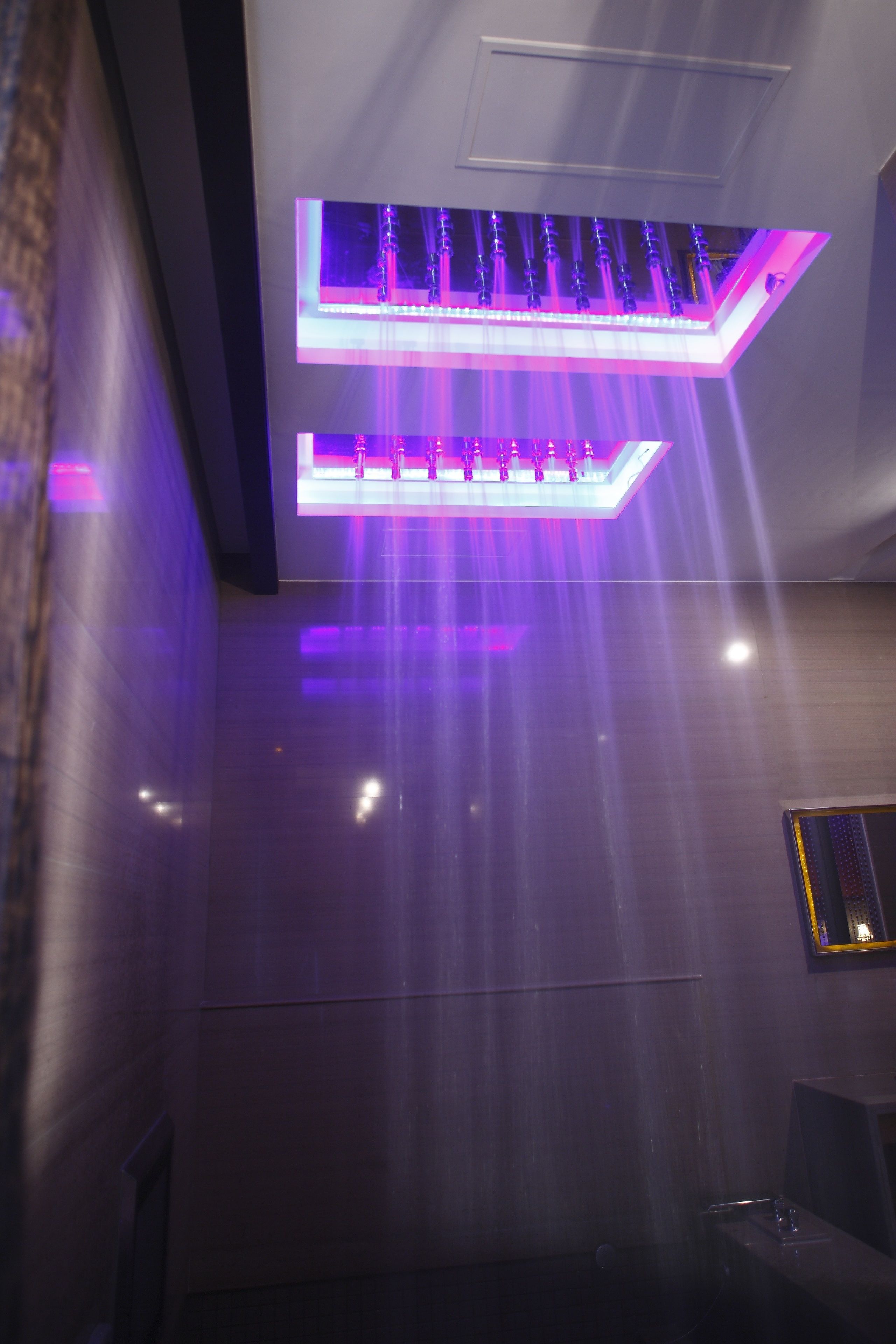 A modern interior with a ceiling-mounted light fixture and a wall-mounted panel.