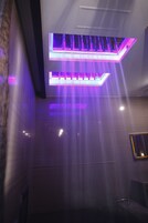 A modern interior with a ceiling-mounted light fixture and a wall-mounted panel.