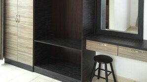 A modern bedroom with a wardrobe, a vanity with a mirror, and a stool. - Cameron Highlands Premier Apartment at Crown Imperial Court (Brinchang)