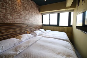 A hotel room with a brick wall, a large window, and a bed with white bedding. - R10 Eco Hotel (Kaohsiung)