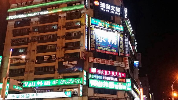 A multi-story building with various signs indicating services such as a hotel, language schools, and a beauty salon.