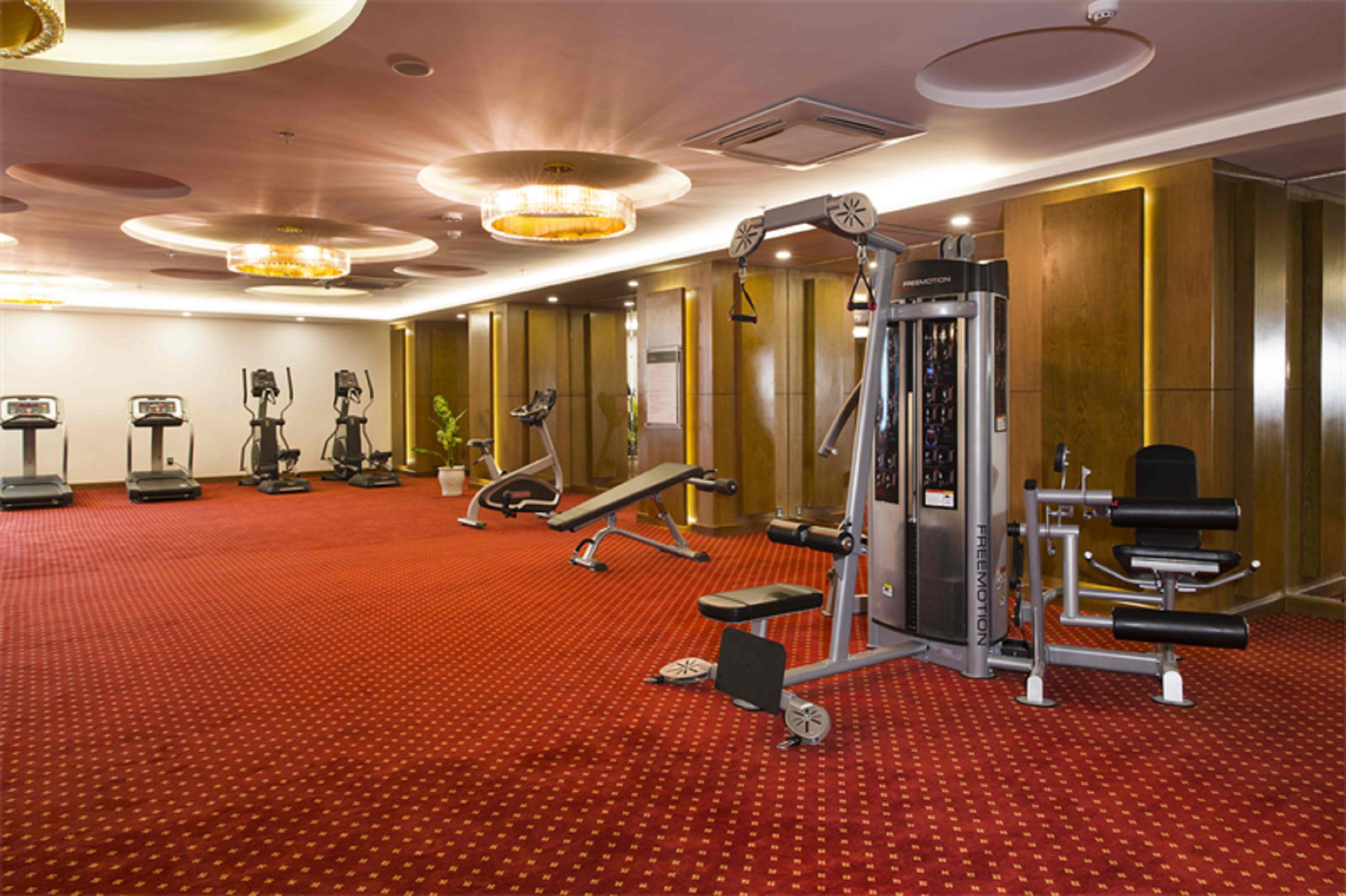 A gym with treadmills, elliptical machines, and weight equipment.