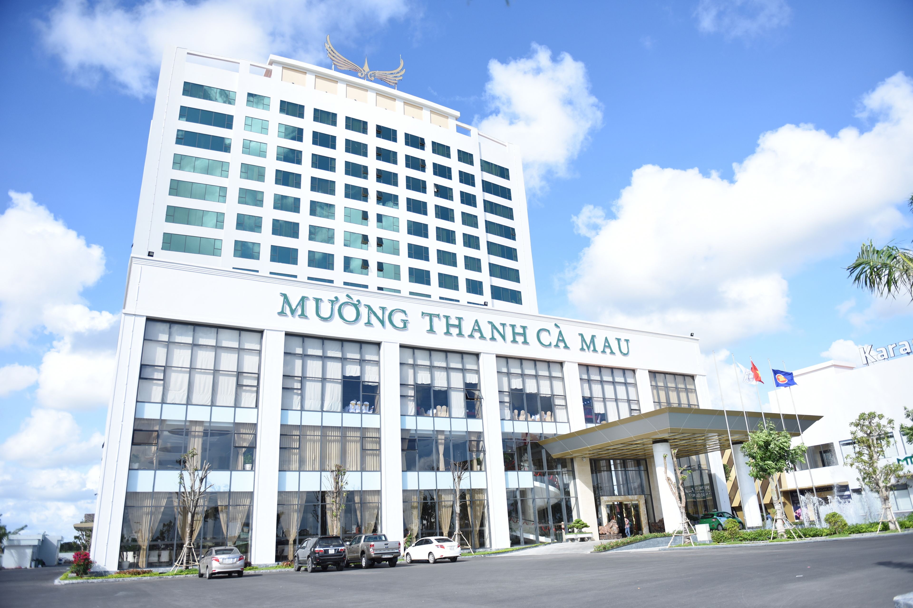 A modern hotel building with a large glass facade and a prominent entrance.
