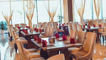 A restaurant with multiple tables and chairs, arranged in a spacious and well-lit interior.