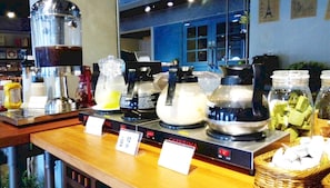 A buffet area with various food dispensers and a sign indicating 'CAFFÈRINA'. - Tourism Inn (Tainan)