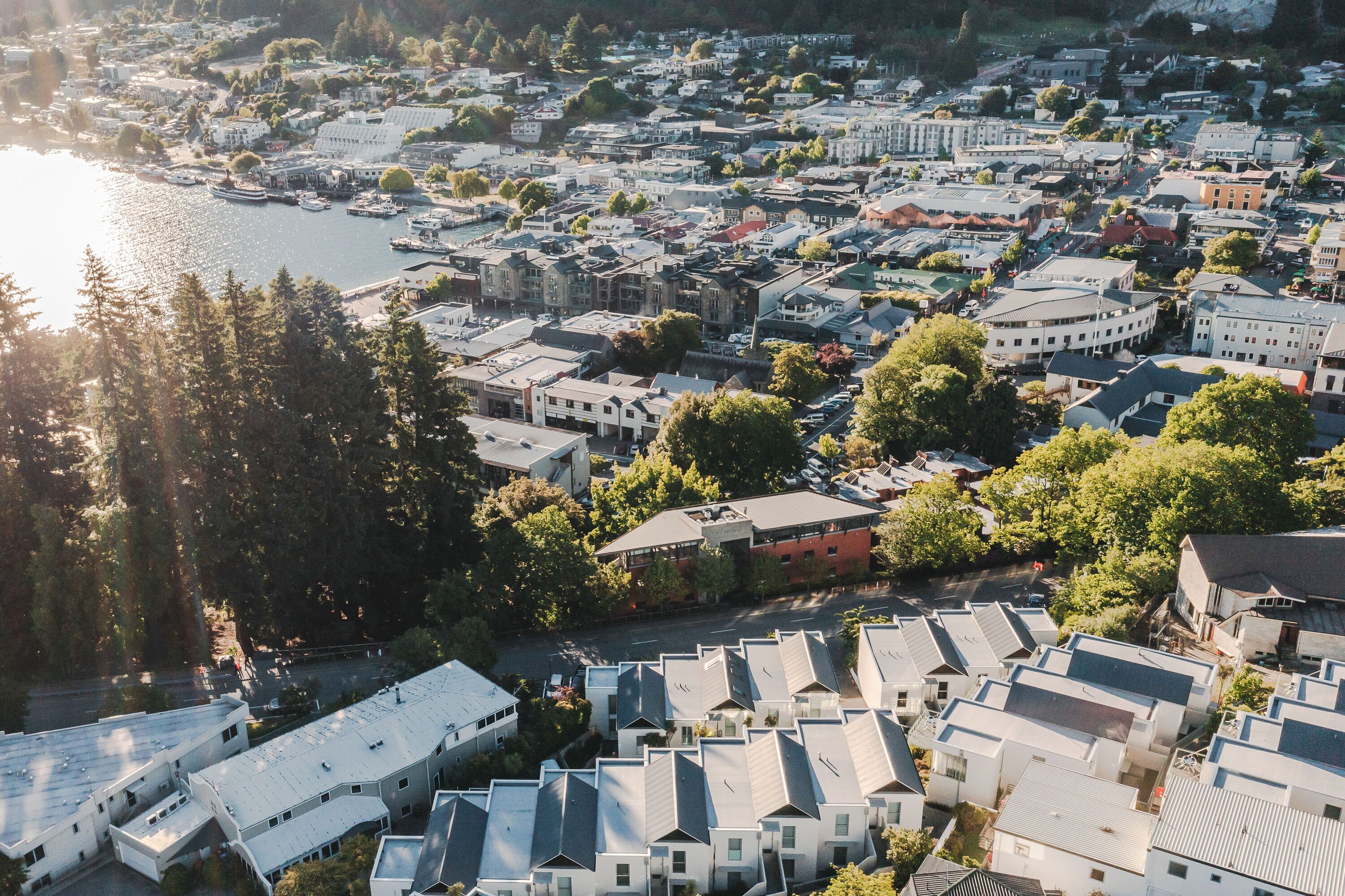 Vue aérienne d’une ville côtière avec des immeubles résidentiels, un port de plaisance et une rivière.