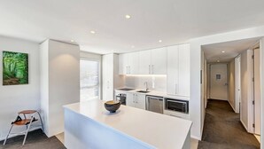 Una cocina moderna con armarios blancos, una isla central y un microondas.