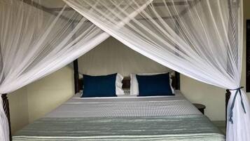 A bed with a canopy, two pillows, and a bedside table.