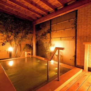 A hot spring bath area with wooden flooring, a wooden bench, and a bamboo wall. - Ryotei Takano (Chikuma)
